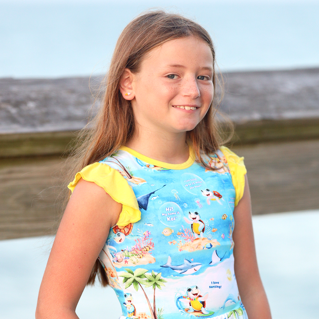 Young girl wearing peplum top and shorts meet kai the sea turtle yellow shorts