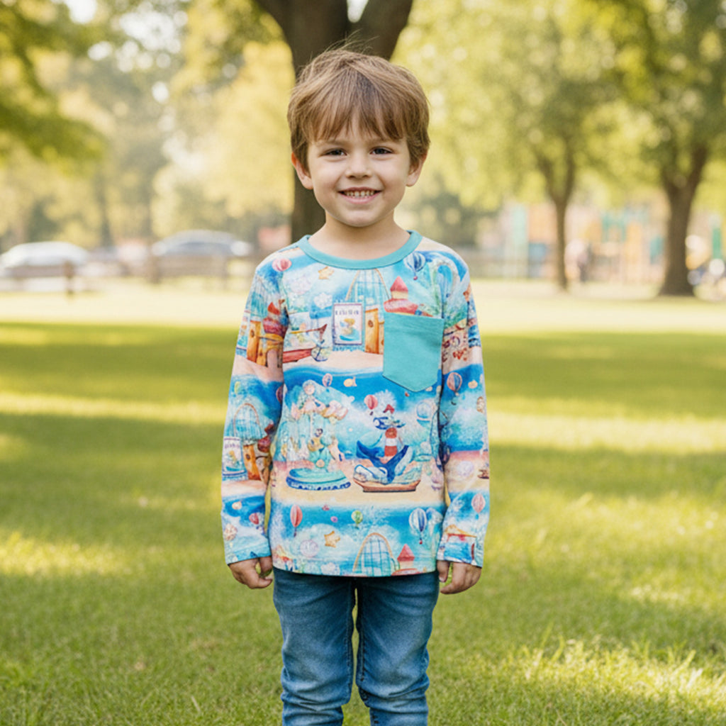 Boy wearing a colorful long-sleeve bamboo tee shirt with n underwater carnival design in a park