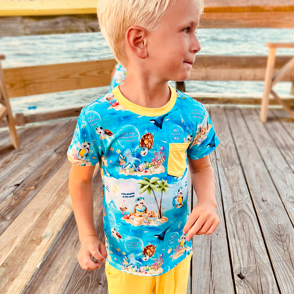 Boy on the dock wearing Kai Blue's Meet Kai bamboo two tee shirt and shorts