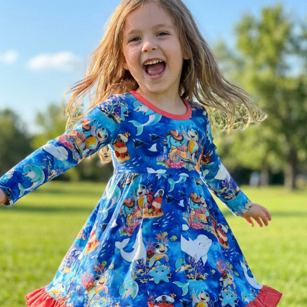 Child dancing in a bamboo dress with ocean-themed print by Kai Blue™